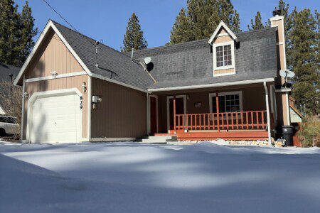Papa Bear Den vacation rental cabin in Big Bear, California — cozy mountain home with front porch and snow-covered driveway