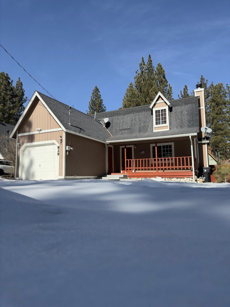 Papa Bear Den vacation rental cabin in Big Bear, California — cozy mountain home with front porch and snow-covered driveway