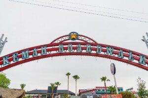 Kemah Boardwalk entrance sign with red arch and palm trees in Kemah Texas on Galveston Bay