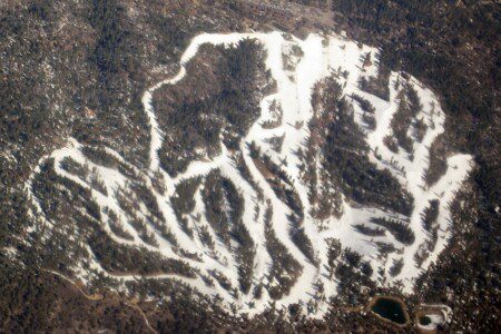 Snow Summit Ski Resort aerial view with snow-covered ski runs and trails in Big Bear Lake California