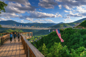 Panoramic view of Gatlinburg SkyBridge with mountain backdrop and flags, featured attraction for things to do in Gatlinburg, Tennessee