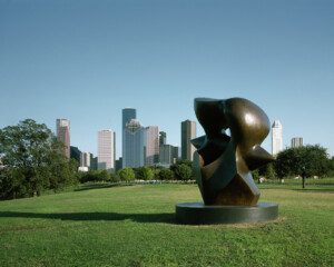 Buffalo Bayou Park Houston skyline with public art sculpture in foreground, green lawns and trees