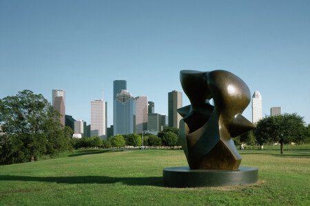 Buffalo Bayou Park Houston skyline with public art sculpture in foreground, green lawns and trees