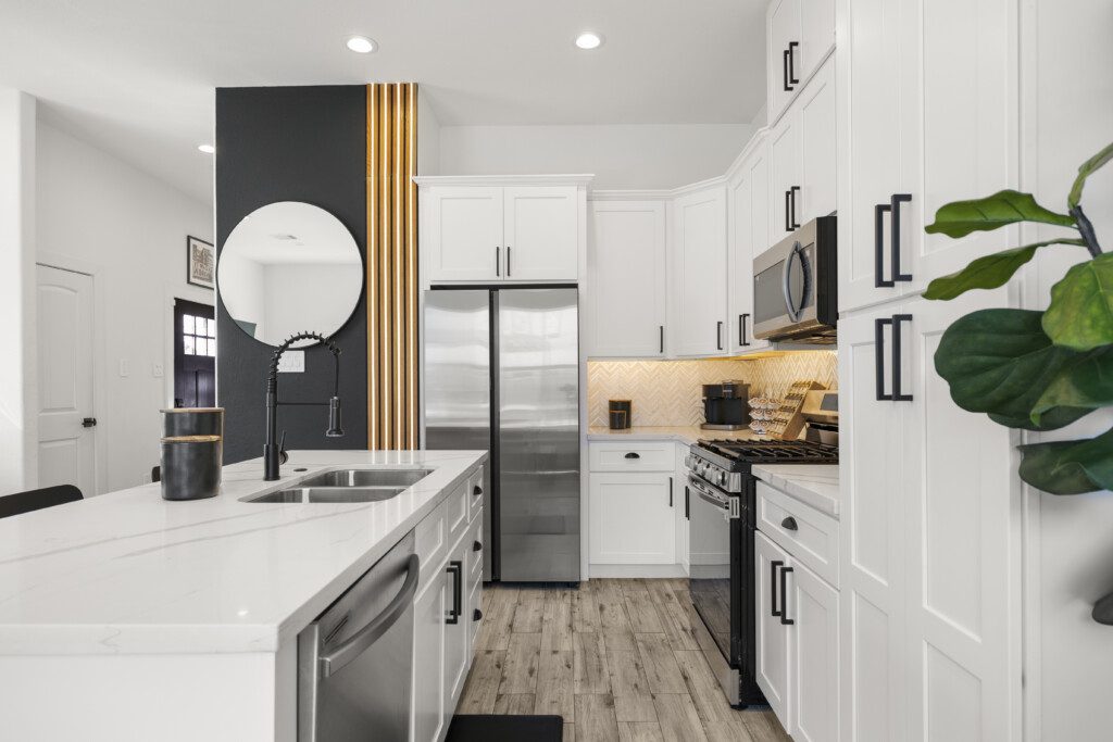 Modern kitchen with island, black accent wall, and stainless appliances at The Landing Pad Houston vacation rental near NRG Stadium