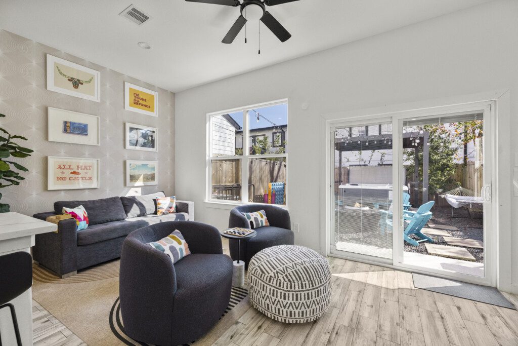 Living room with sliding glass doors to private backyard and hot tub at The Landing Pad Houston vacation rental near NRG Stadium
