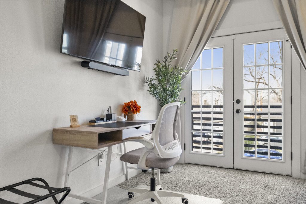 Guest bedroom with workspace, Smart TV, and French doors at The Landing Pad Houston vacation rental near NRG Stadium