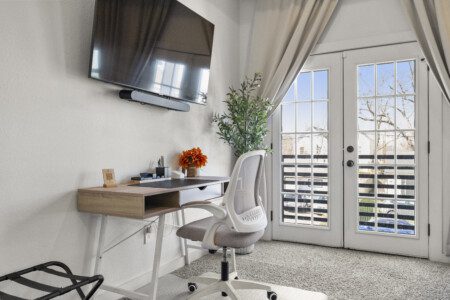 Guest bedroom with workspace, Smart TV, and French doors at The Landing Pad Houston vacation rental near NRG Stadium