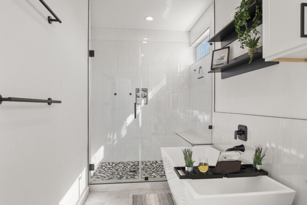 Spacious primary ensuite bathroom with soaking tub and rainfall shower at The Landing Pad Houston vacation rental near NRG Stadium