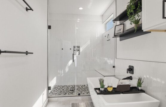 Spacious primary ensuite bathroom with soaking tub and rainfall shower at The Landing Pad Houston vacation rental near NRG Stadium