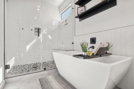 Luxurious primary bathroom with soaking tub and walk-in shower at The Landing Pad Houston vacation rental near NRG Stadium