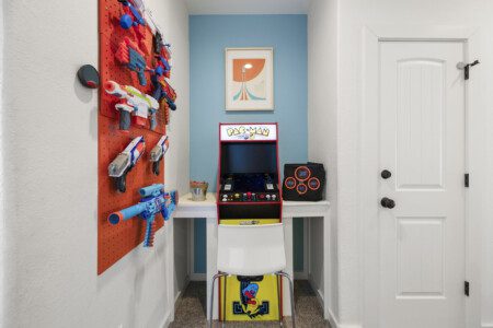 Vintage Pac-Man arcade game with blue accent wall at The Landing Pad Houston vacation rental near NRG Stadium