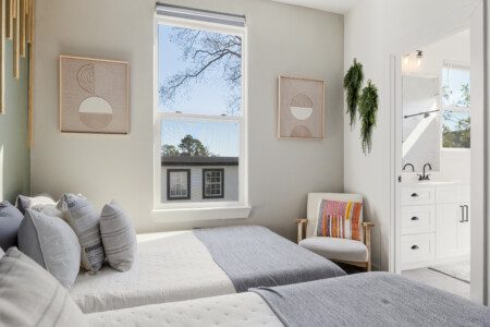 Guest bedroom with two beds and vanity at The Landing Pad Houston vacation rental near NRG Stadium and Houston Zoo