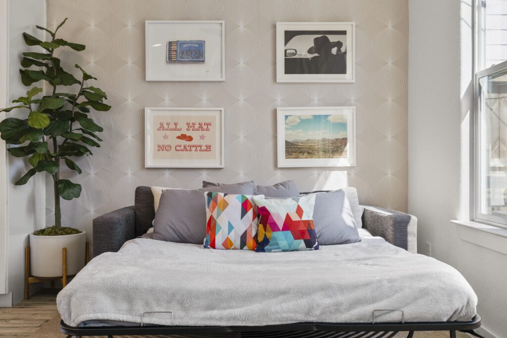 Living room queen sleeper sofa with Texas gallery wall at The Landing Pad Houston vacation rental near NRG Stadium