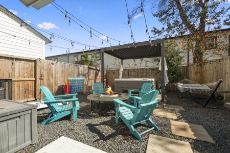 Private backyard with fire pit, hot tub, and seating at The Landing Pad Houston Airbnb
