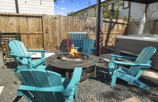 Backyard fire pit and hot tub area at The Landing Pad Houston Airbnb with private seating