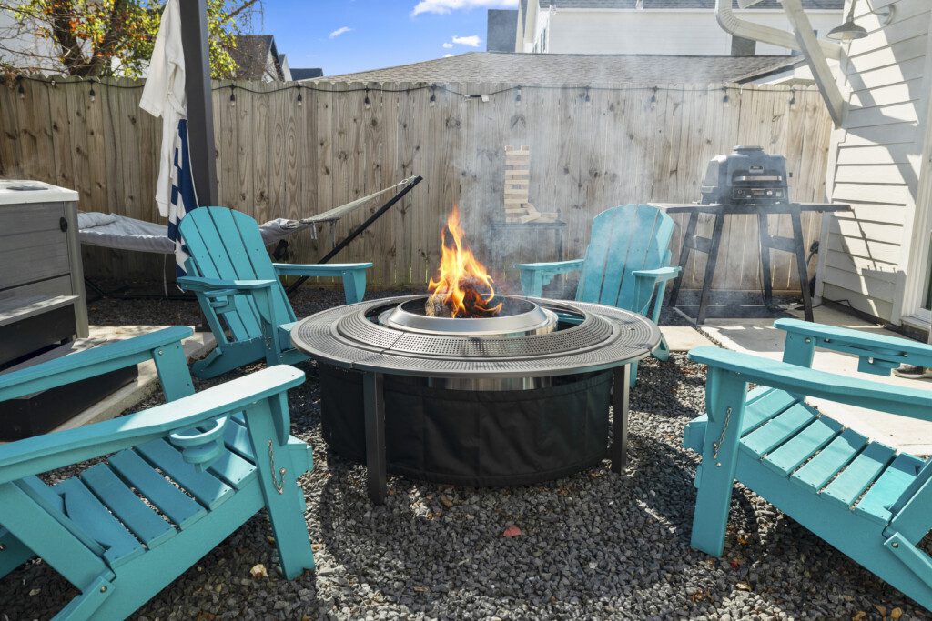 Outdoor fire pit seating area at The Landing Pad Houston Airbnb with Adirondack chairs
