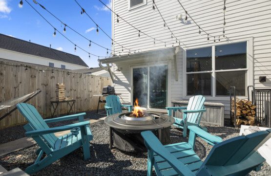 Backyard fire pit seating area at The Landing Pad Houston Airbnb with string lights and private patio