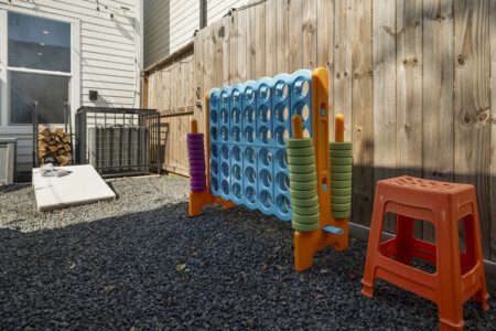 Family-friendly backyard at The Landing Pad Houston Airbnb with outdoor games and fenced yard